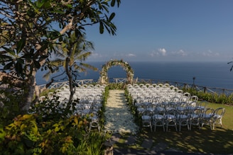 white chairs and green and white floral arch
