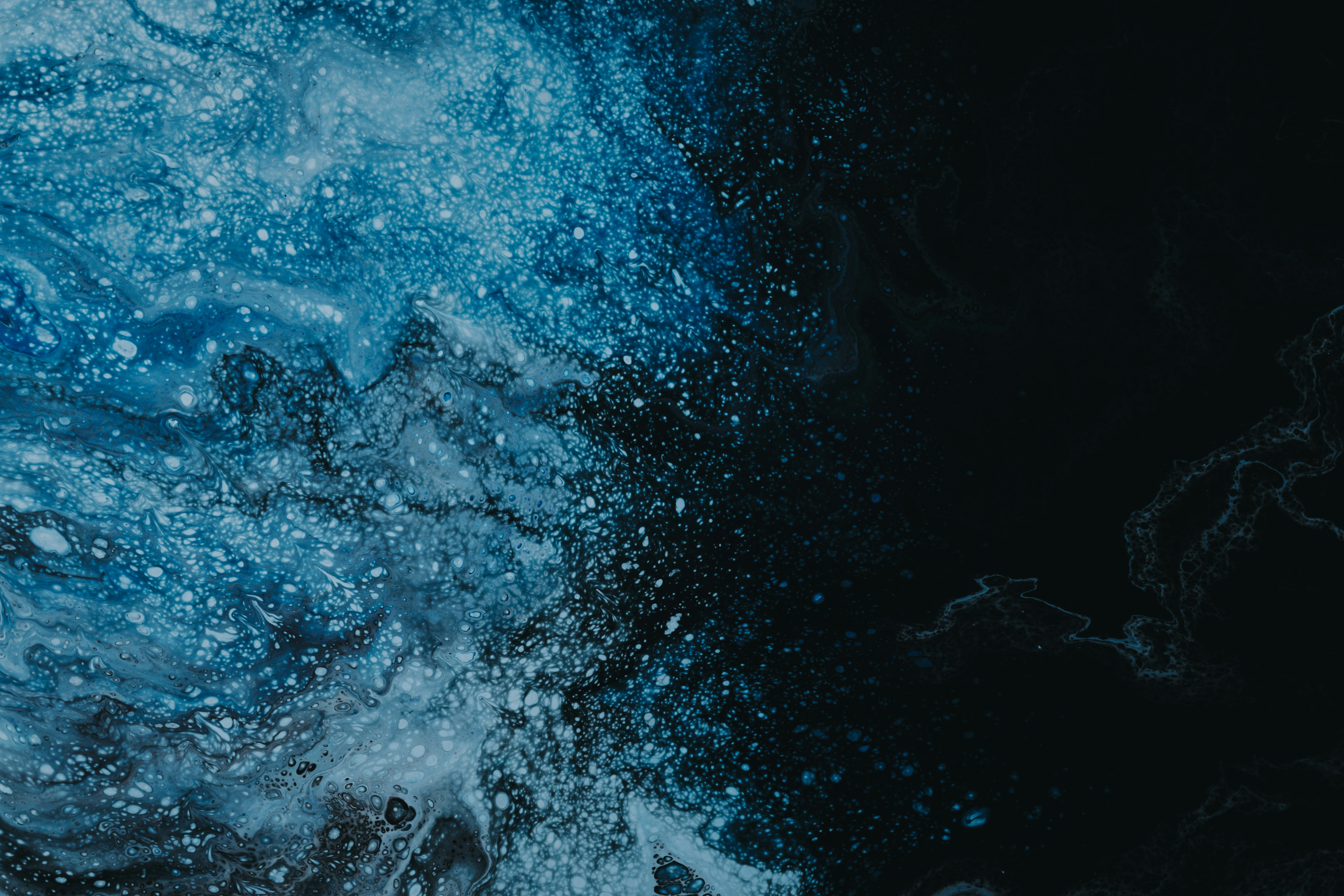 a black and blue background with water splashing on it