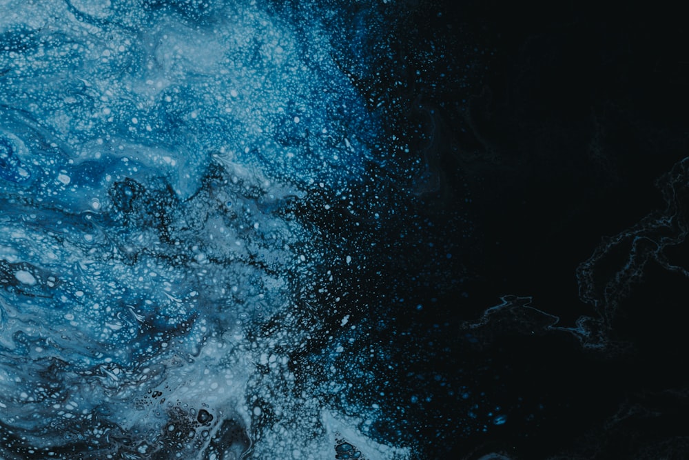 a black and blue background with water splashing on it