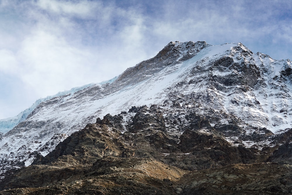 a large mountain covered in snow under a blue sky