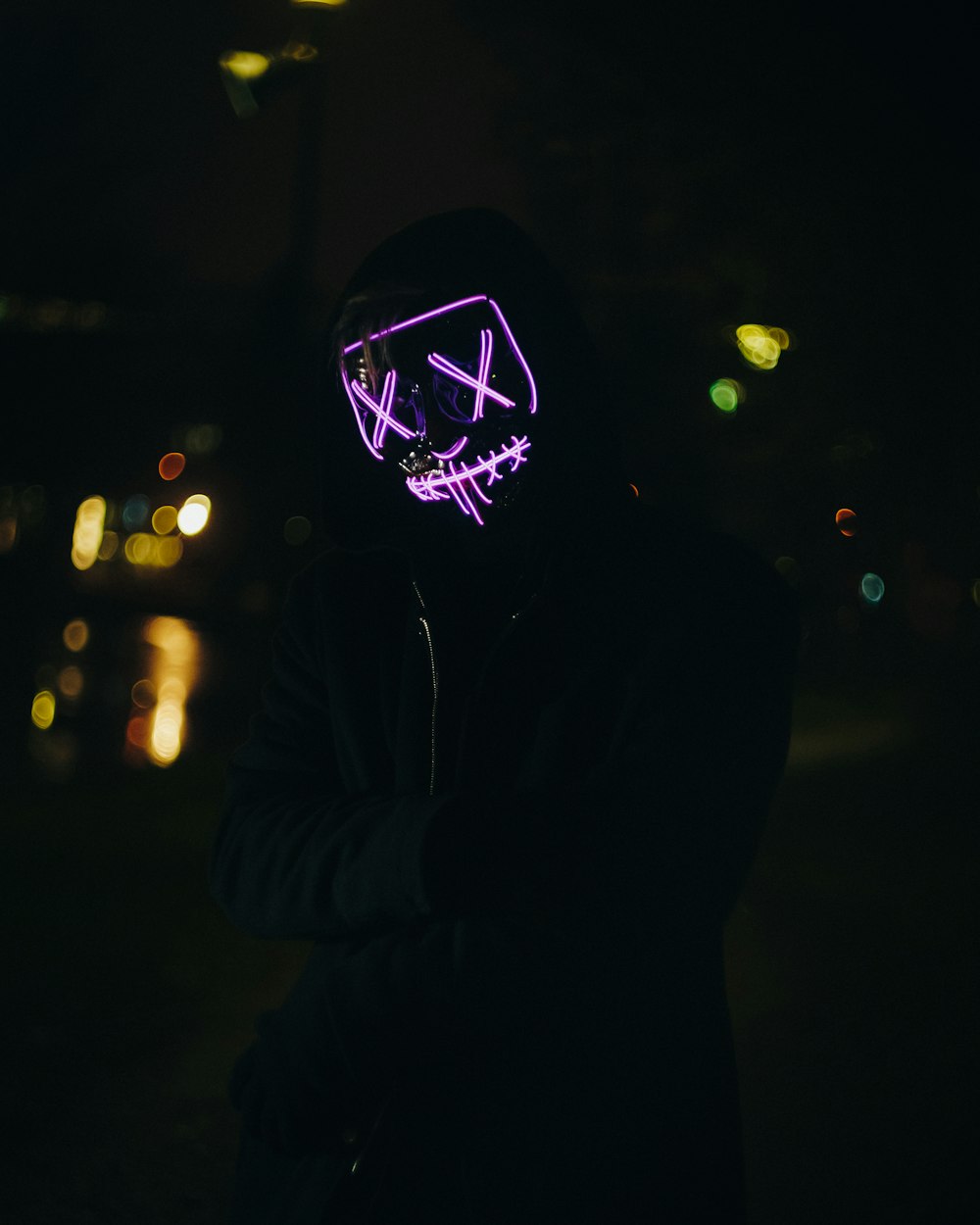 a person wearing a neon mask in the dark