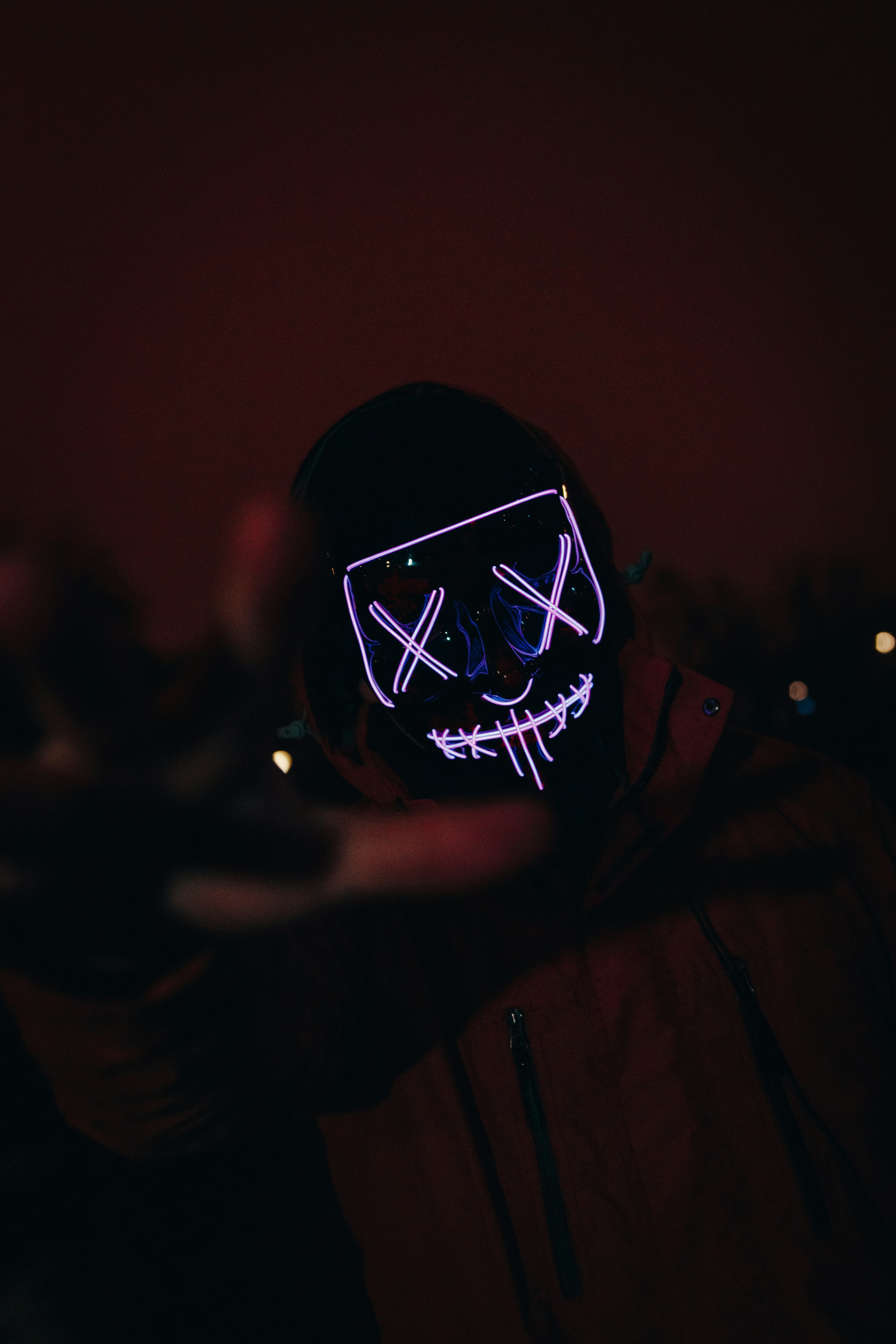 a person wearing a neon mask in the dark