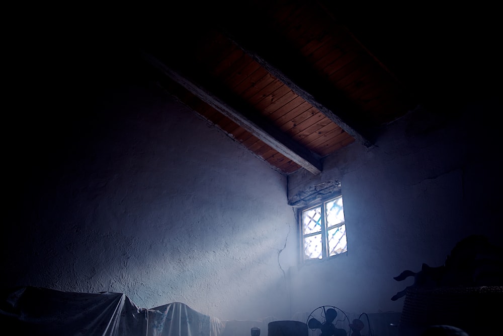 a dark room with a light coming through a window