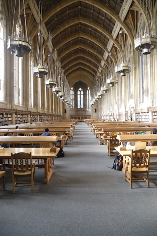 Students studying together in a bright library filled with theological books and Pentecostal materials.
