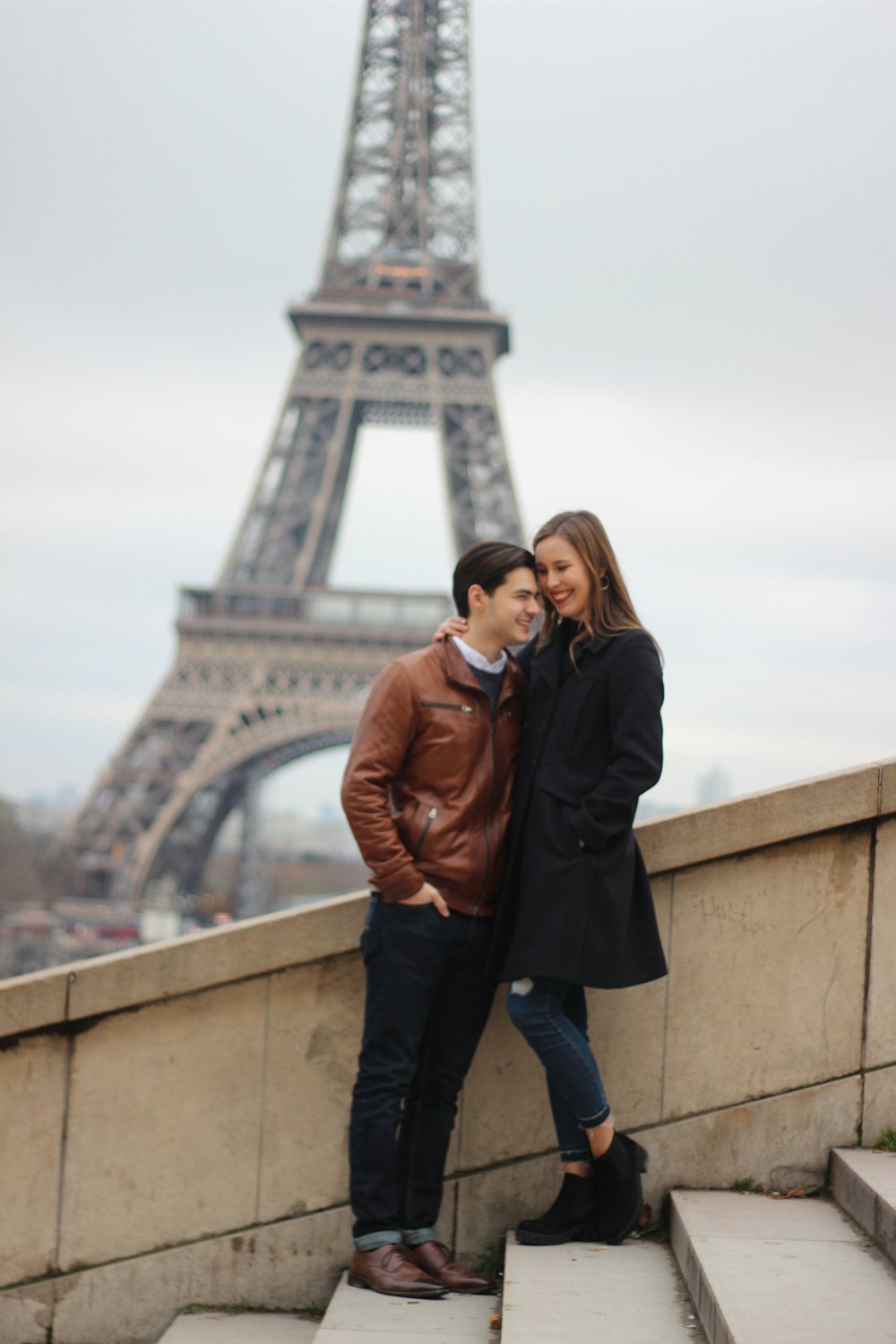 man and woman standing on stairs behind of Eiffel Tower