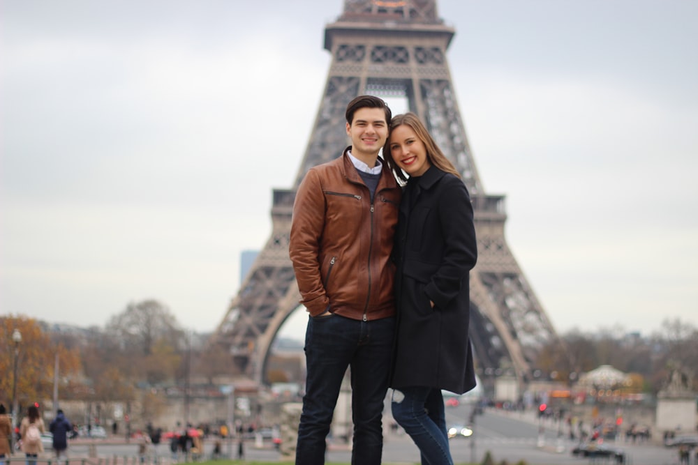 woman and man standing behind of Eiffel Tower