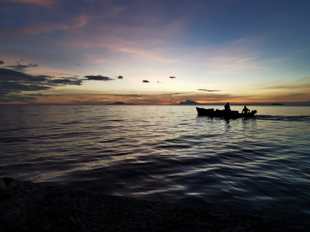 silhouette of people riding canoe boat