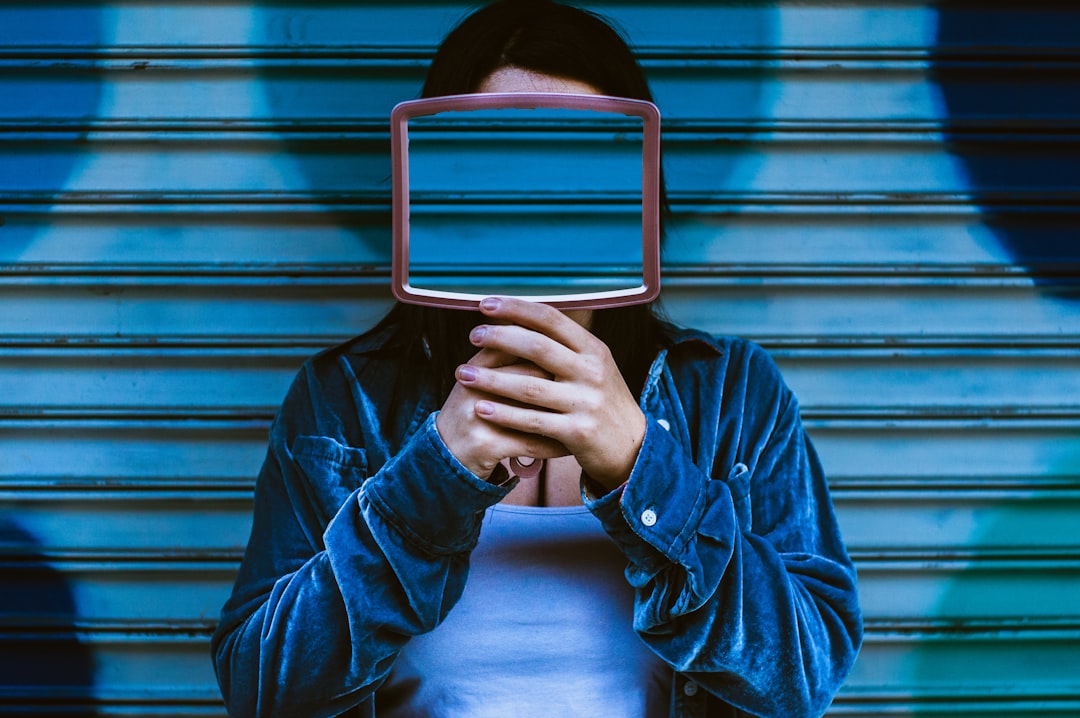 man covering face with mirror,