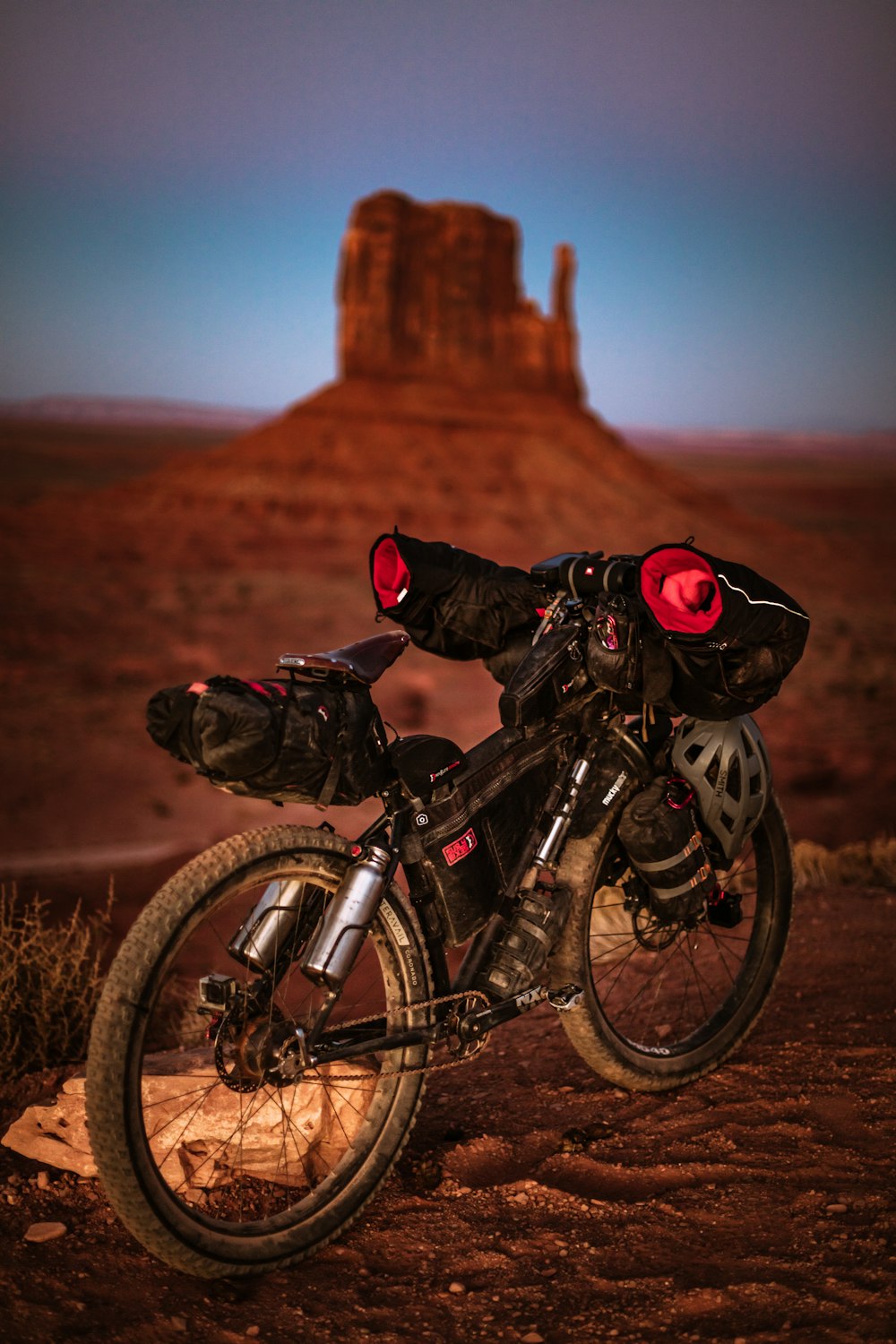 a motorcycle parked on a dirt road in the desert