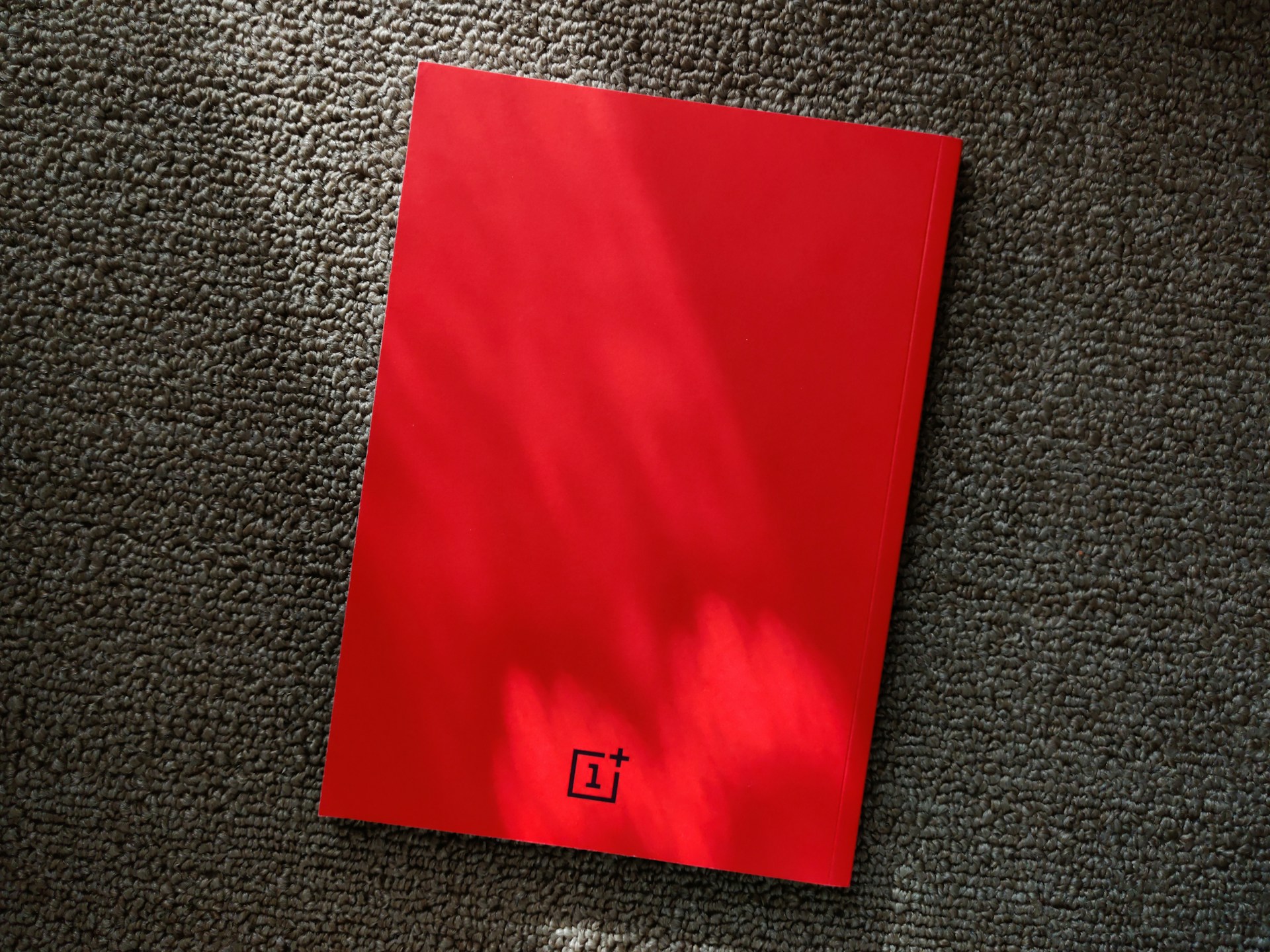 A stylish notebook with a custom logo on the cover, placed on a white surface with soft natural lighting.