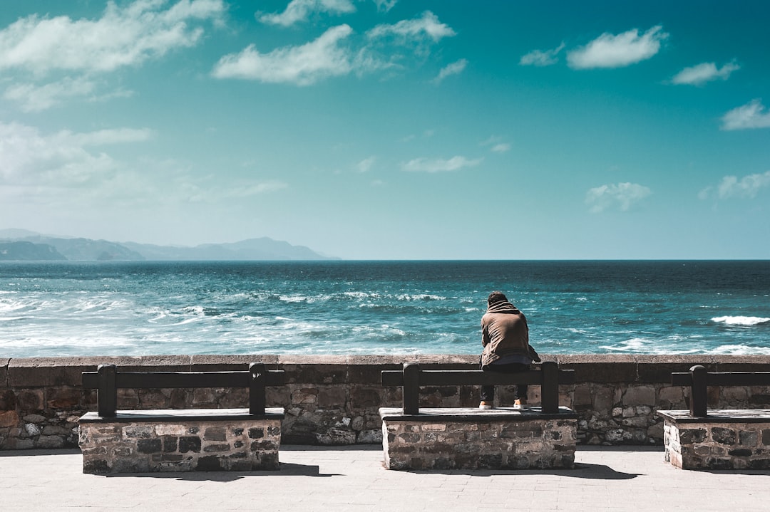 man facing ocean under blue sky