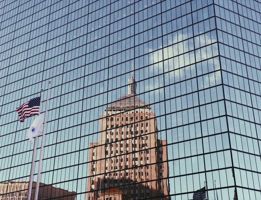 reflexión sobre el edificio marrón en el edificio de vidrio