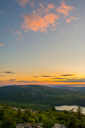 A scenic view of a mountain landscape at sunset.