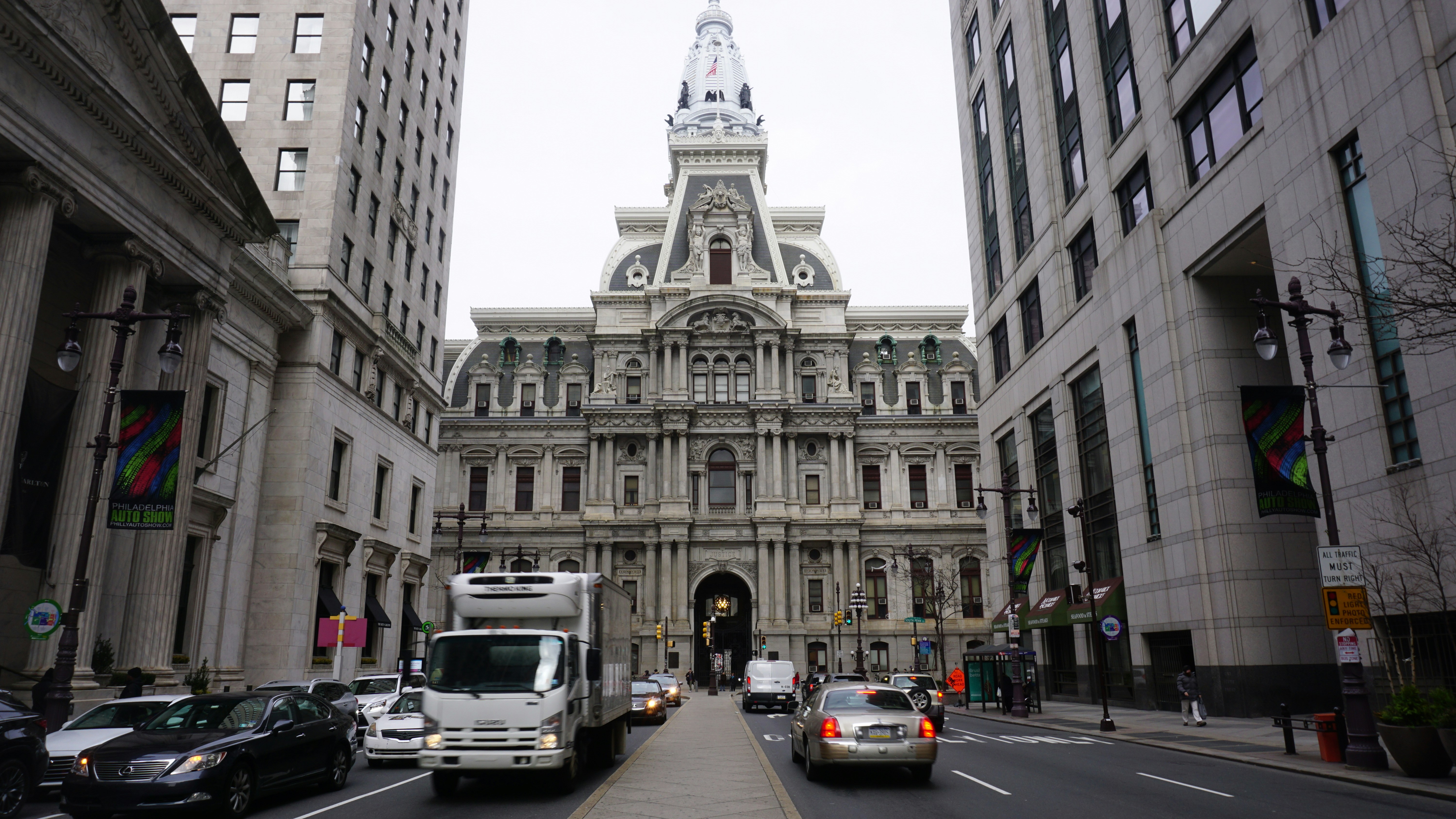 view photography of vehicles between gray concrete buildings during daytime