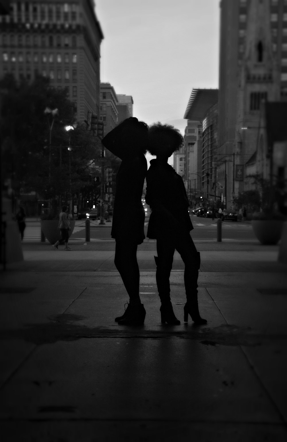 grayscale photography of person standing near building