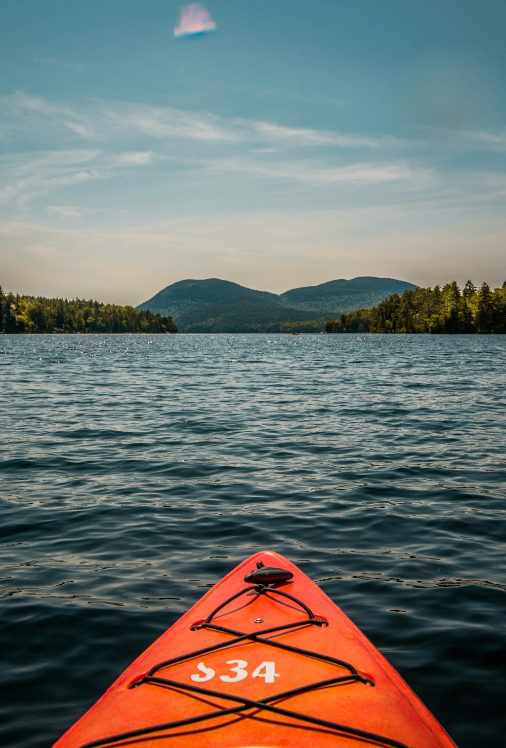 orange kayak on body of water