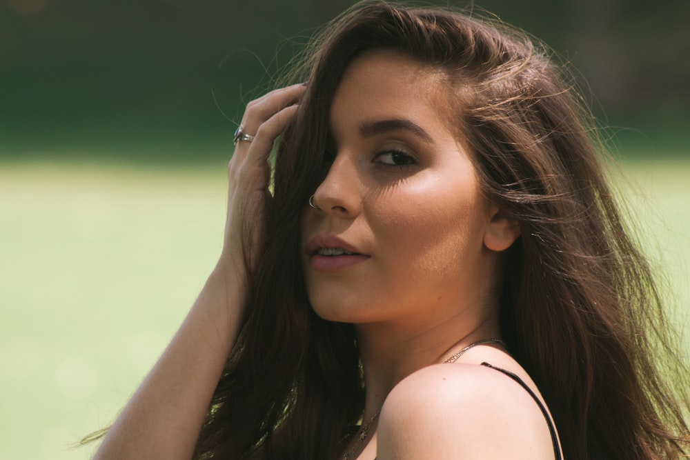 woman in black top touching her hair during daytime