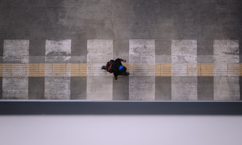 high angle photo of person walking on pedestrian lane