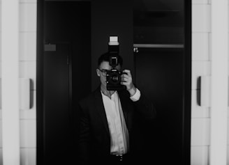 Photographer capturing candid moments while guests use the mirror booth at a stylish party.