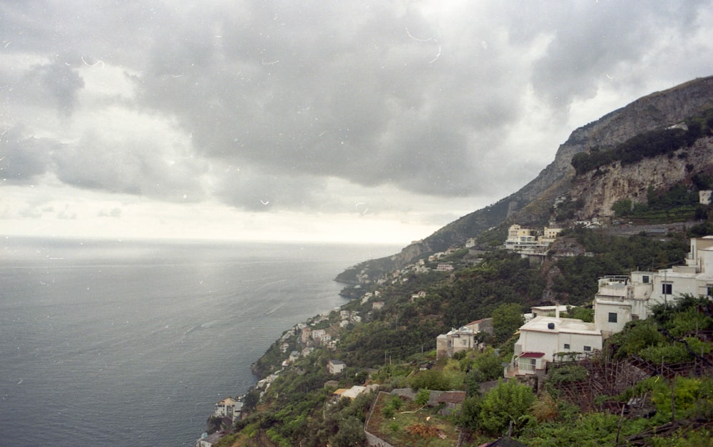 aerial photography of houses in mountain near sea during daytime