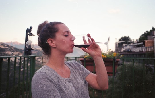 woman drinking wine outside house during daytime in Amalfi Italy