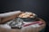 A bowl filled with glazed cookies is set on a wooden board dusted with powdered sugar. Nearby, a wooden rolling pin, metal cookie cutters, and a candy cane are visible, all suggesting a baking theme.