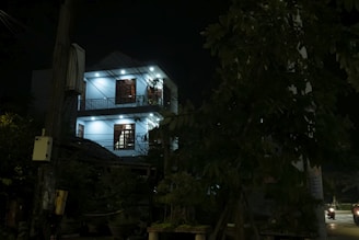 Nighttime exterior of a sleek home illuminated by vibrant blue and magenta RGB lighting accents.