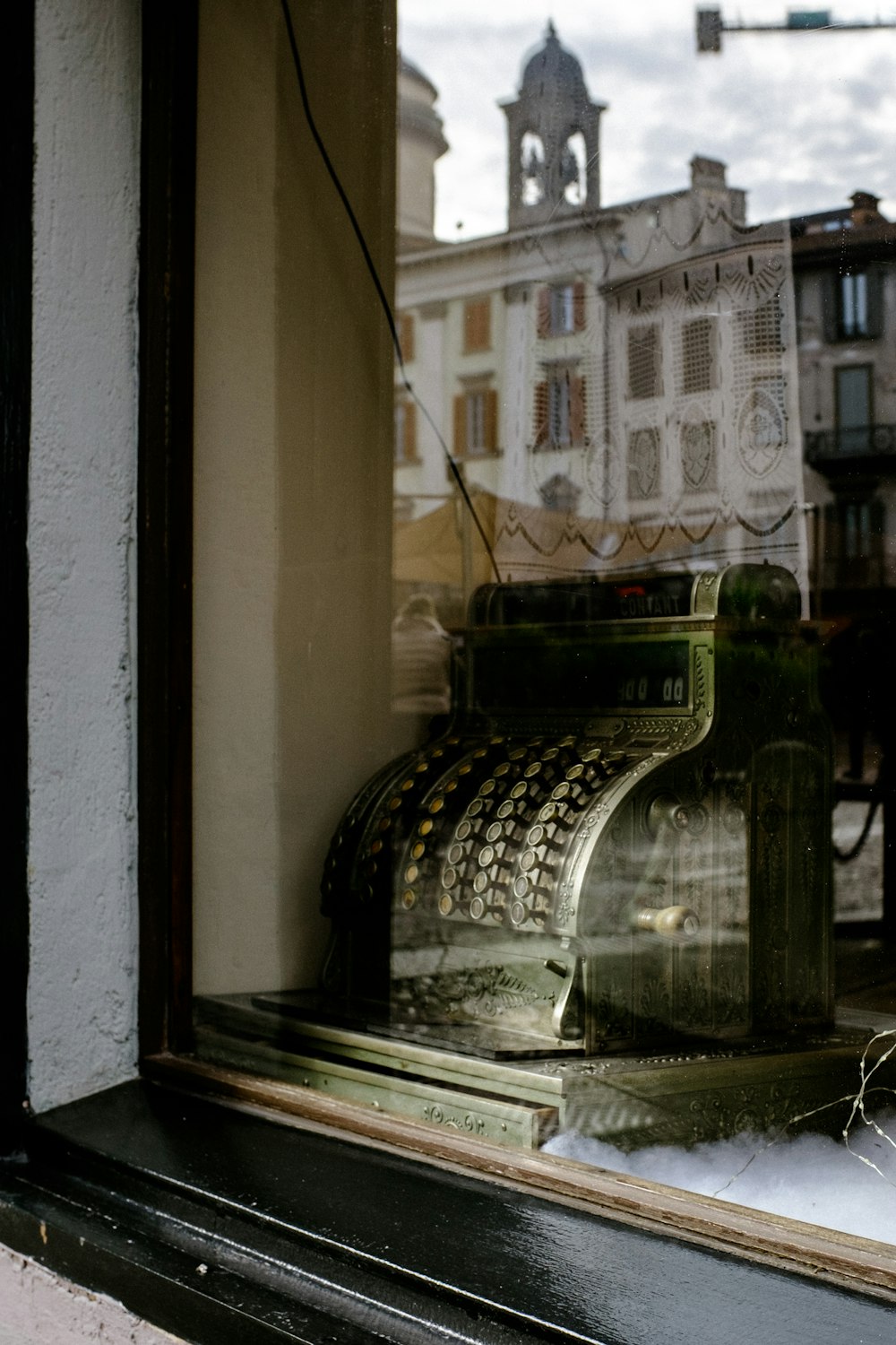 gray adding machine near glass window