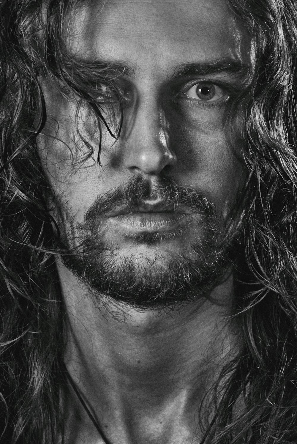 uma foto em preto e branco de um homem com cabelo comprido