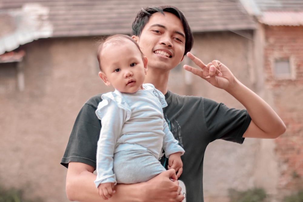 smiling man carrying baby