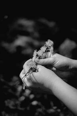 Hands of participants crafting delicate paper flowers, showcasing focus and fine motor skills.