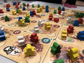 Close-up of colorful meeples and game pieces from various strategy board games.