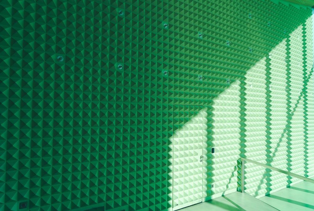 a room with a green wall and a stair case