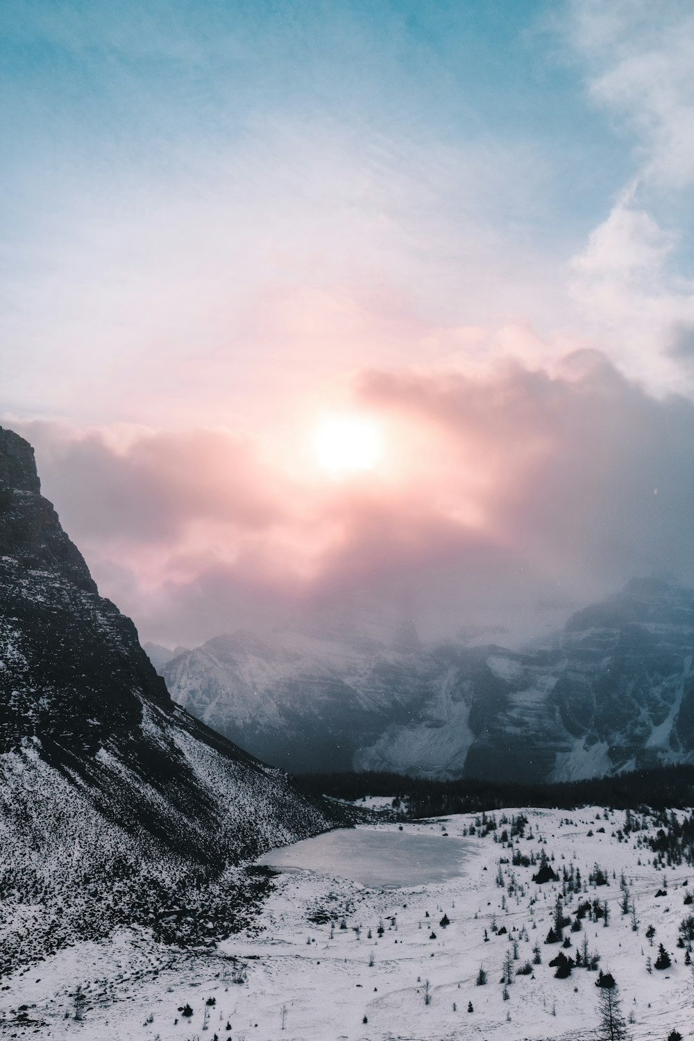 field and mountain covered with snow under white and gray sky