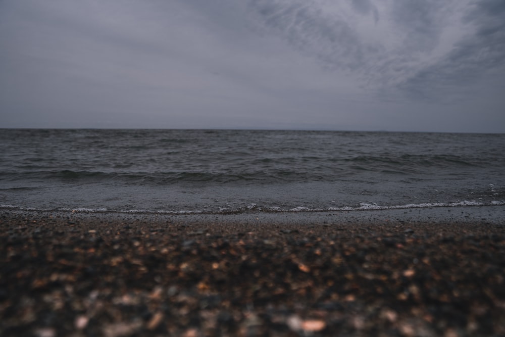 a body of water sitting next to a sandy beach