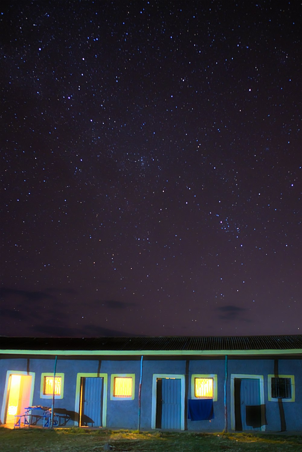 um edifício azul com um céu cheio de estrelas no fundo