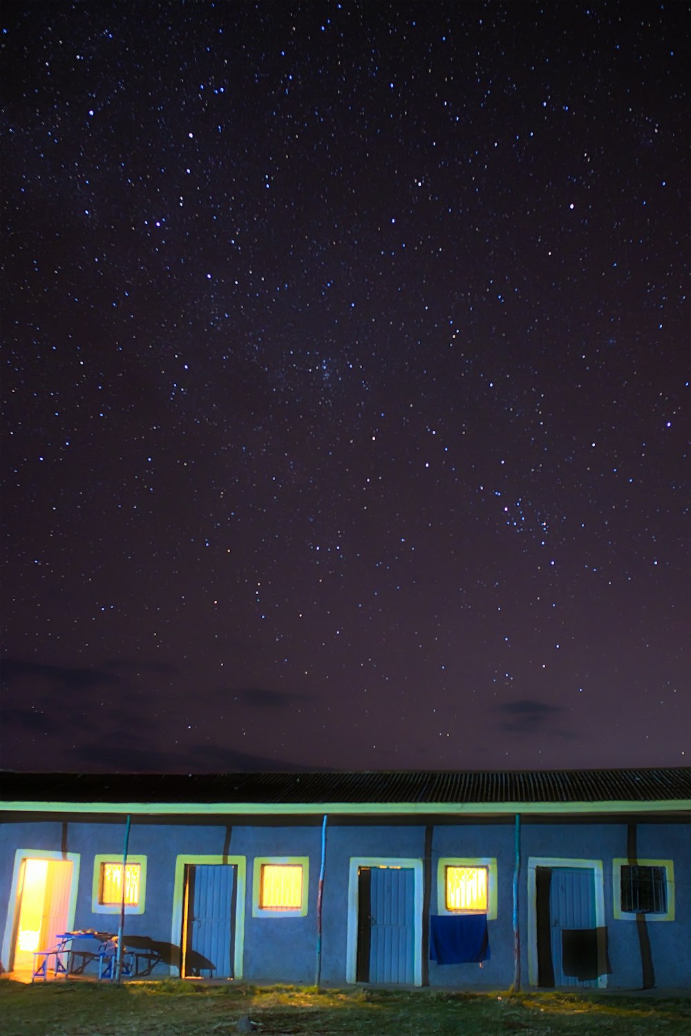 a blue building with a sky full of stars in the background