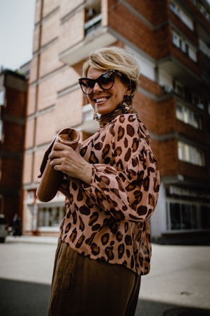 woman wearing brown and beige blouse holding brown pouch bag