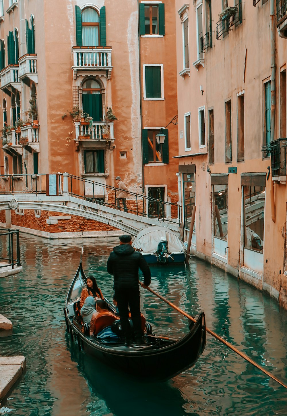 man standing on boat near buildings