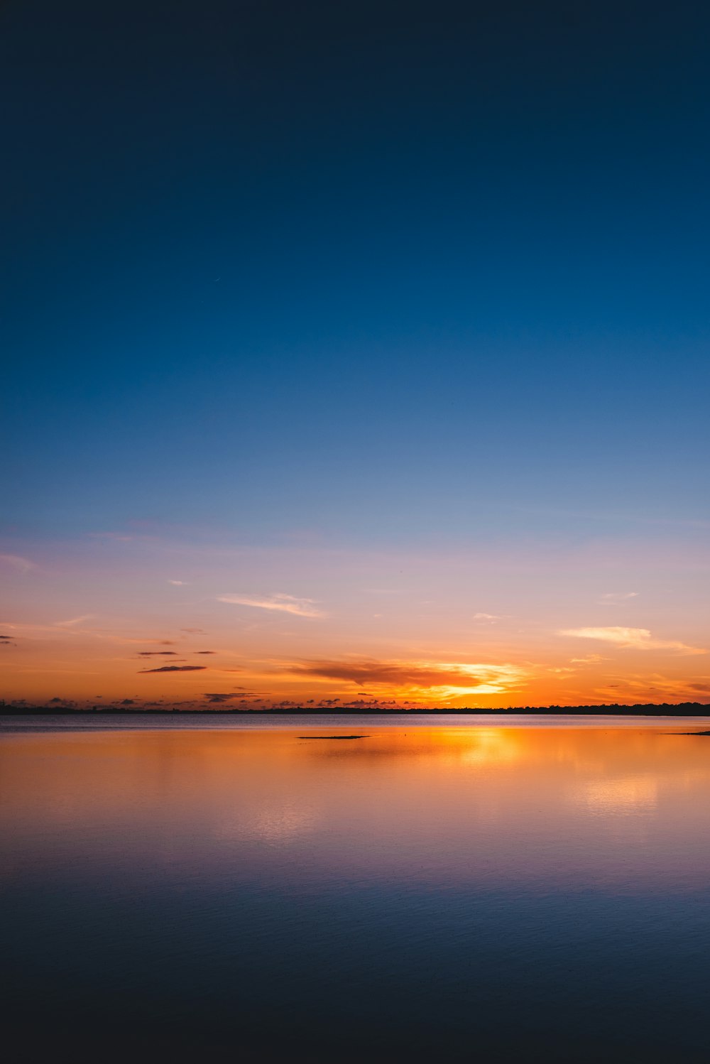 cielo naranja y azul con cuerpo de agua tranquilo