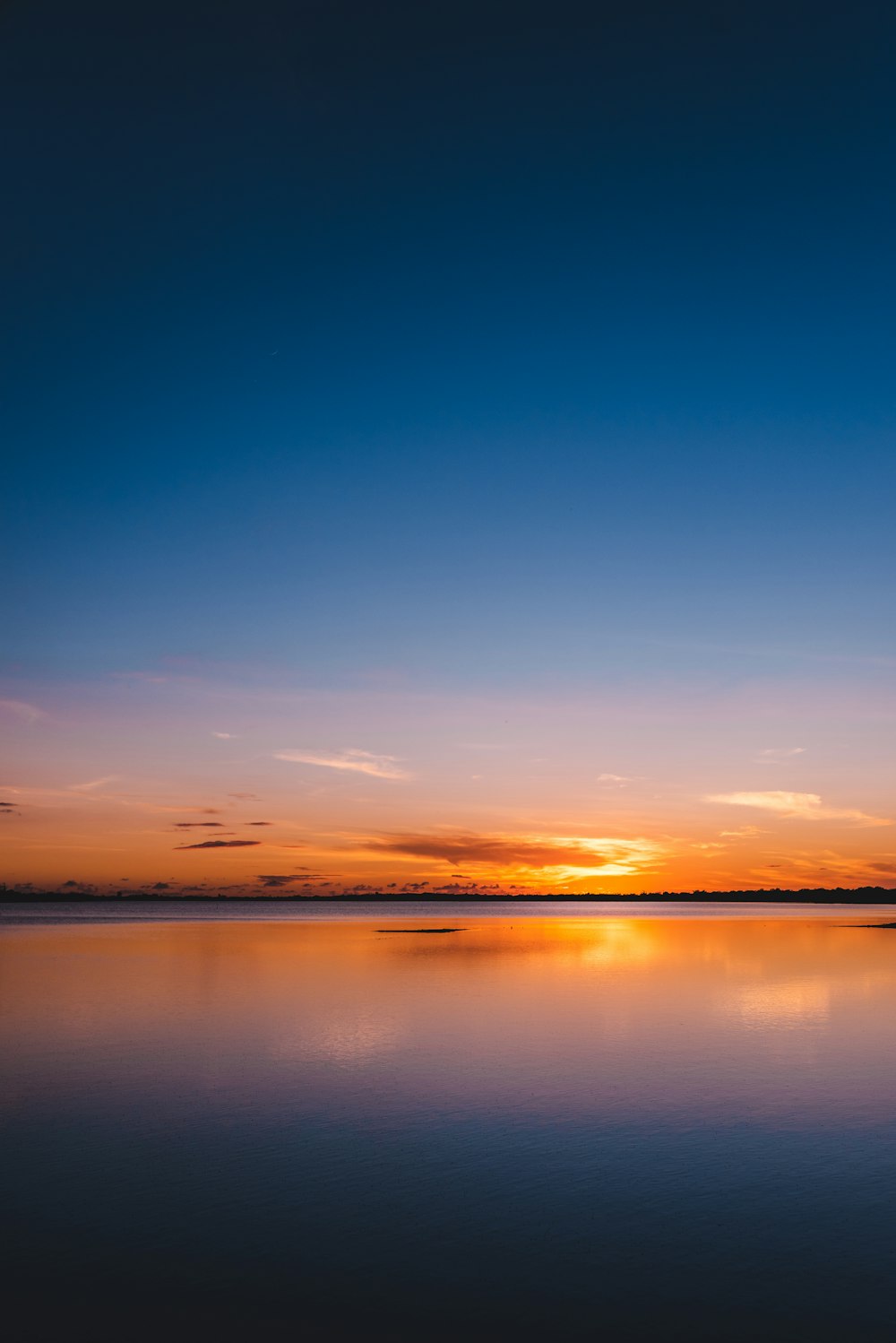 orange and blue sky with calm body of water