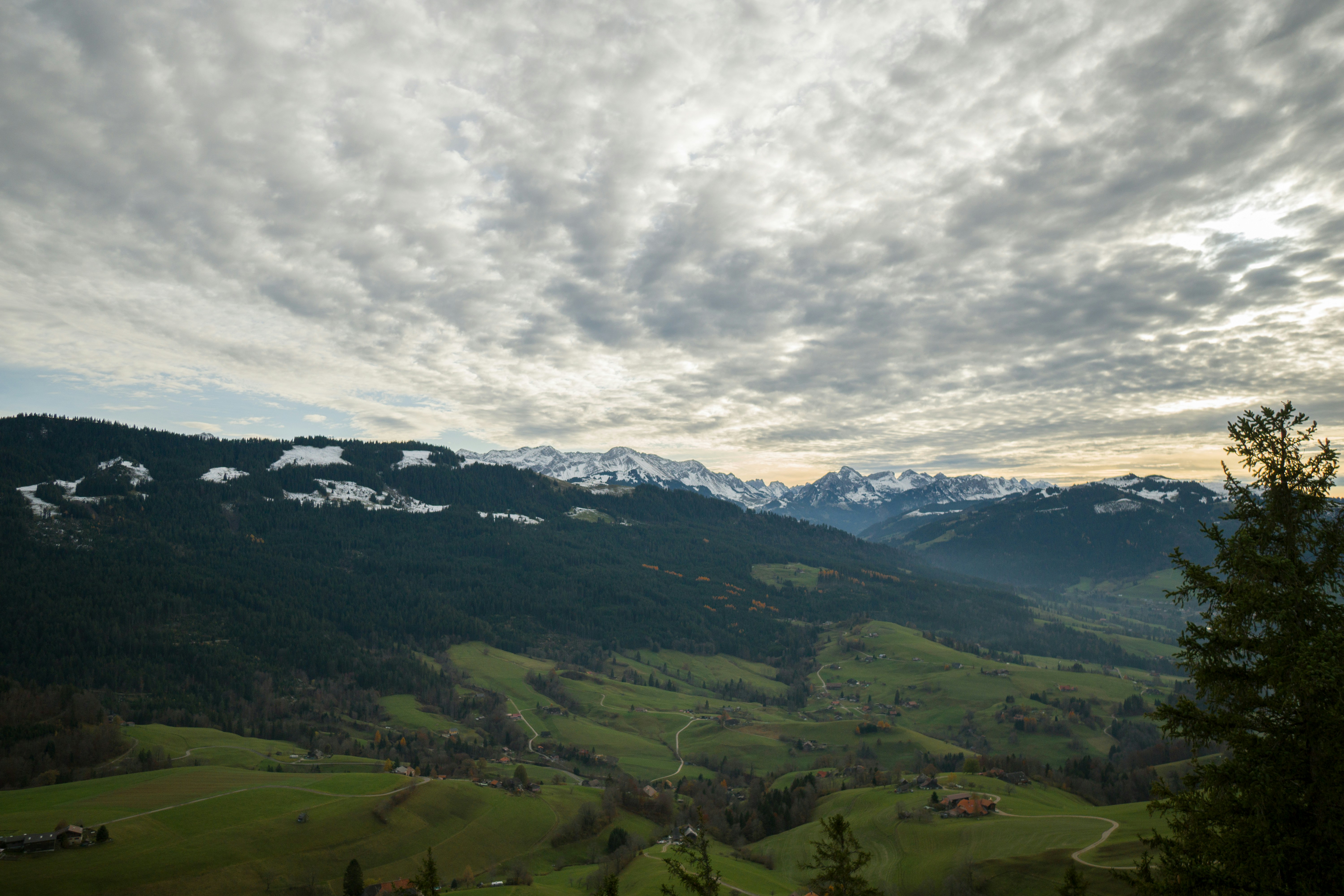 aerial photography of houses on green field viewing mountain under Cumulus clouds