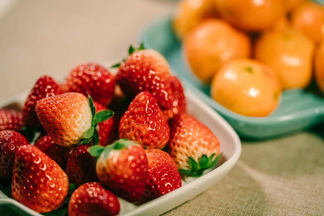 strawberry and orange fruits in bowl