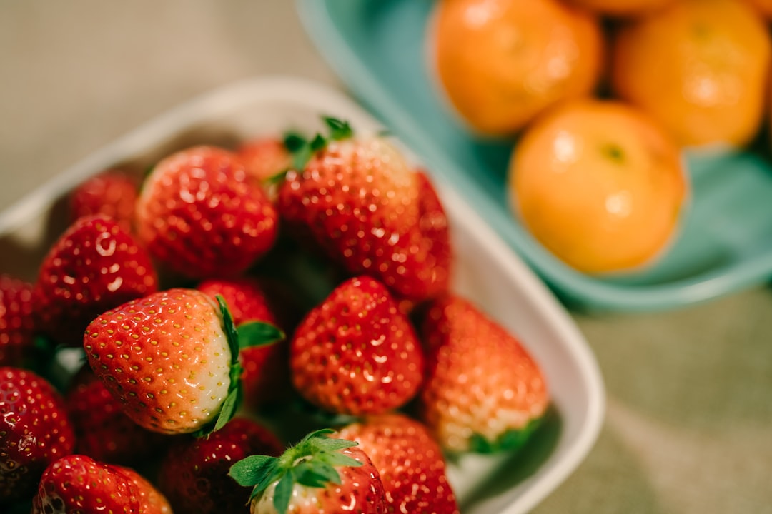 strawberry fruits in bowl and orange fruits in another bowl