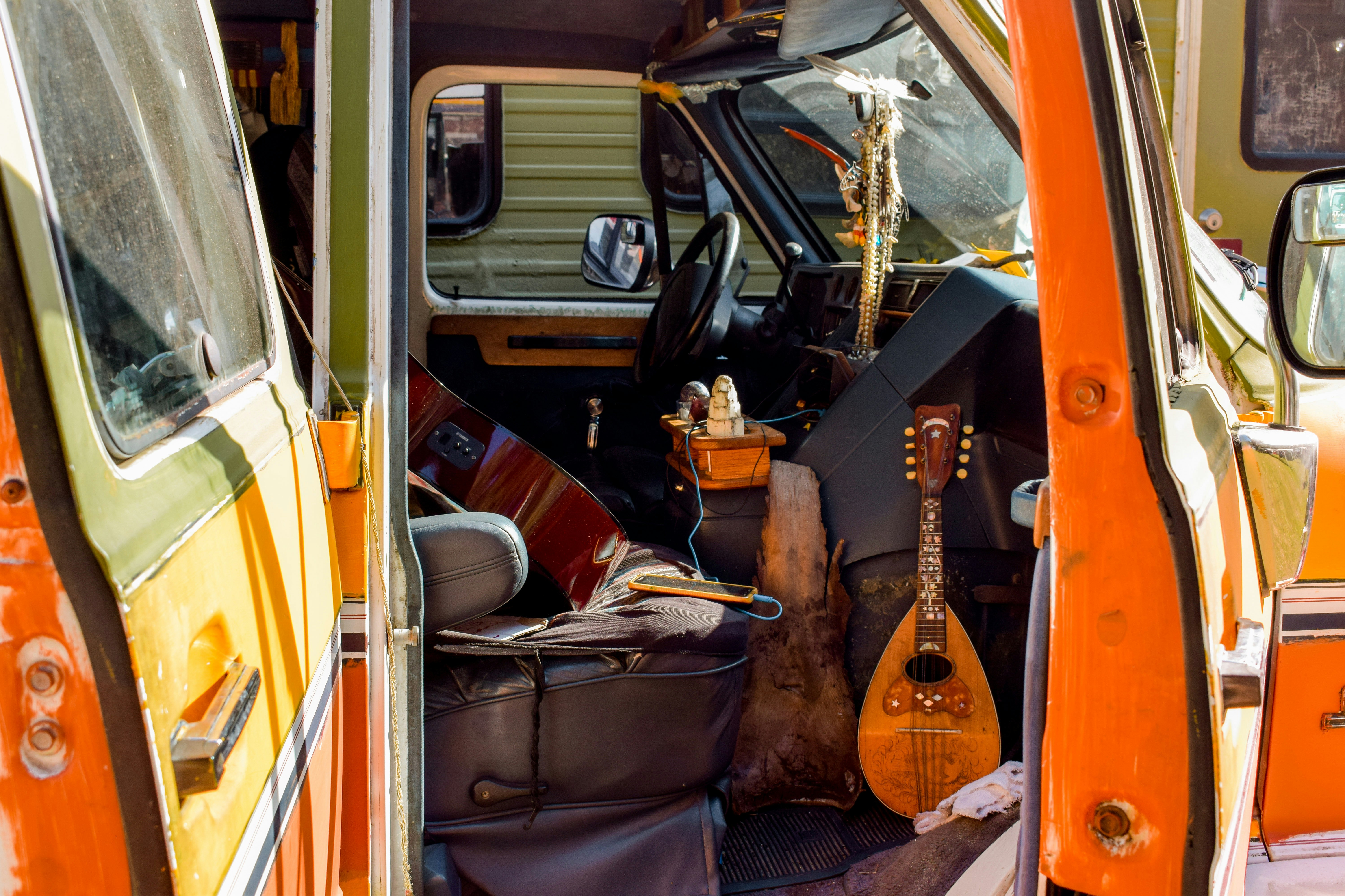 Brown acoustic guitar on black car