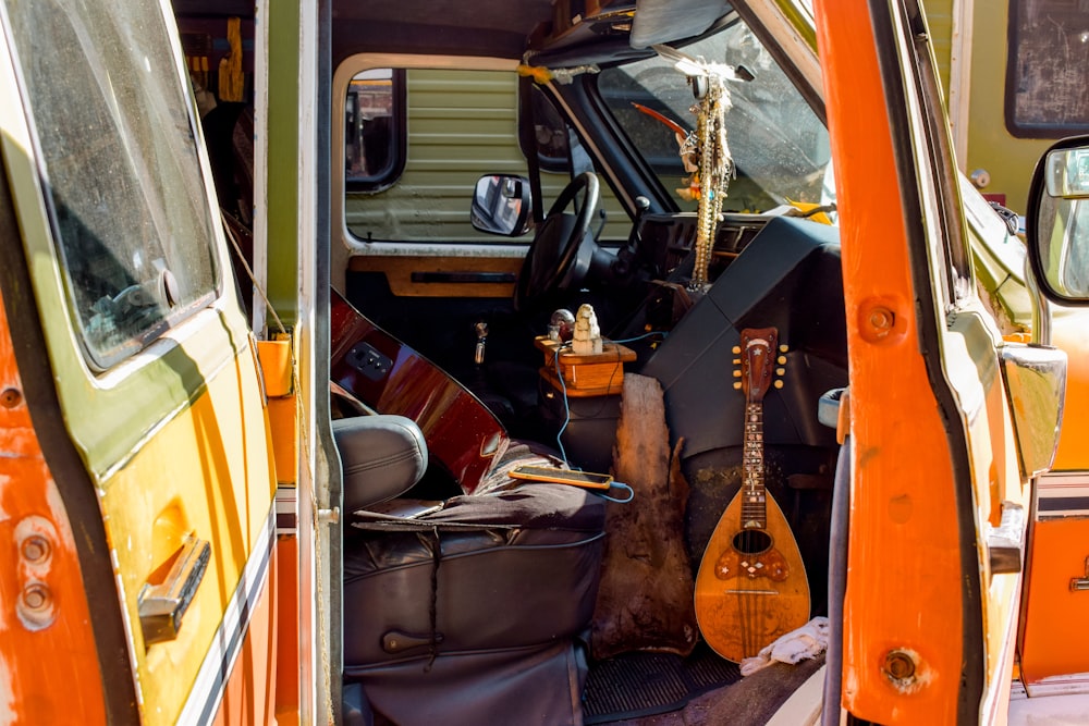 brown acoustic guitar on black car