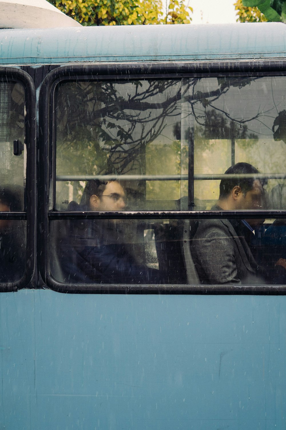 people sitting in blue bus during daytime