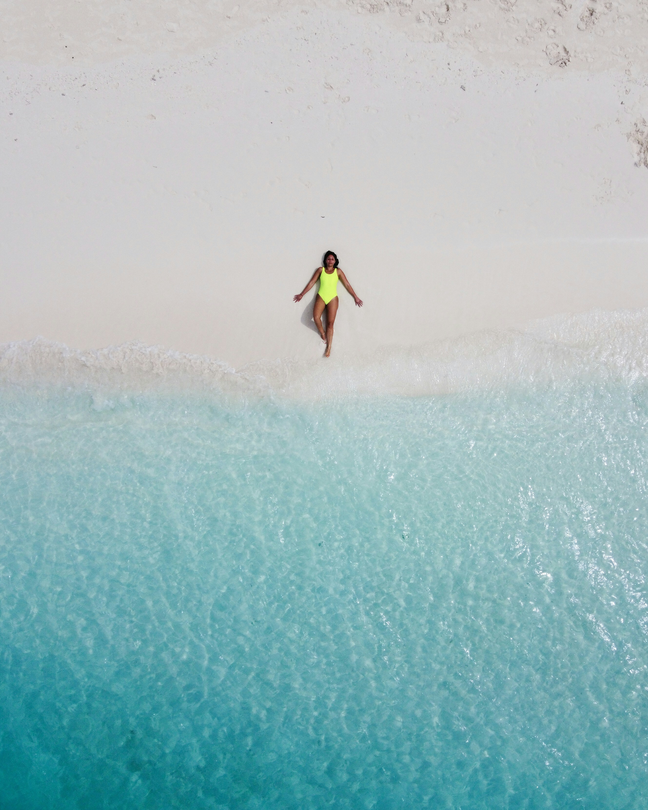 woman wearing green one-piece swimsuit sunbathing near seashore