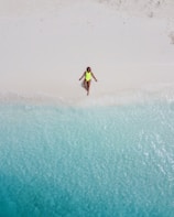 woman wearing green one-piece swimsuit sunbathing near seashore