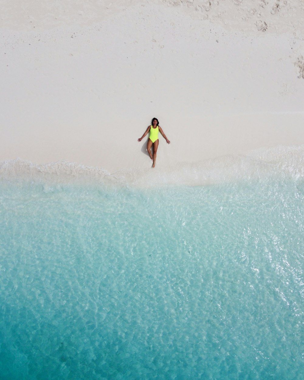 woman wearing green one-piece swimsuit sunbathing near seashore